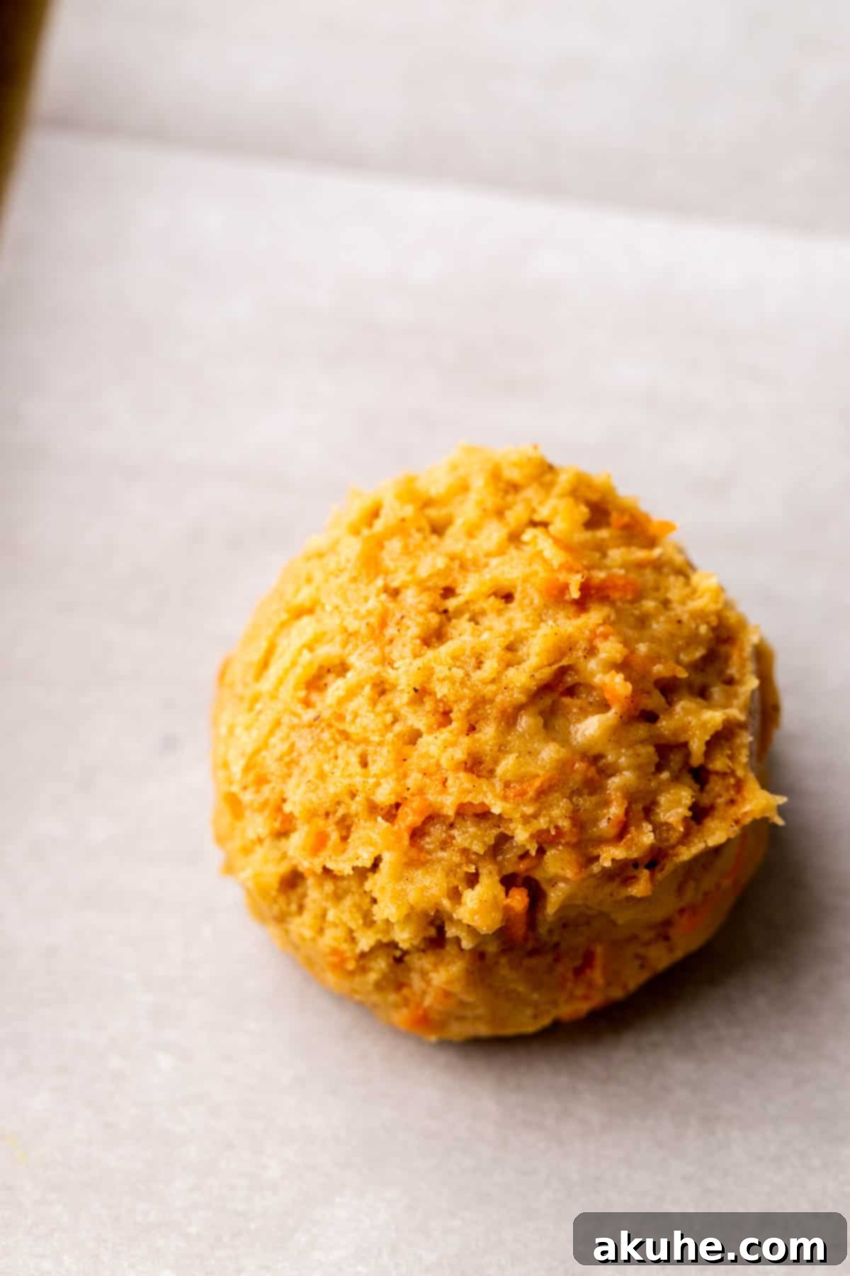 Perfectly formed cookie dough ball with filling, placed on a cookie sheet.