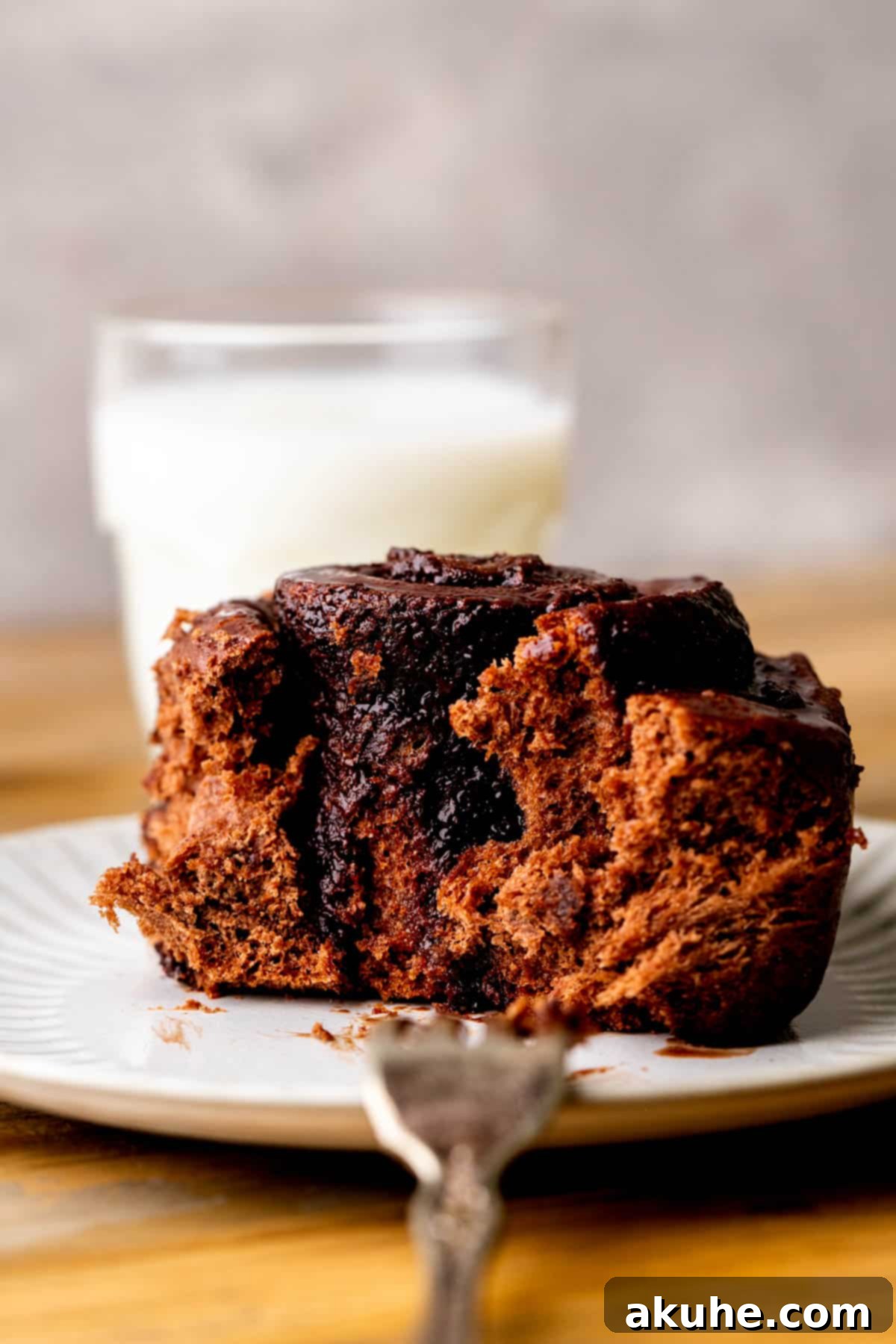 Decadent Chocolate Rolls 3 A single chocolate roll cut in half on a white plate, revealing the rich chocolate filling.