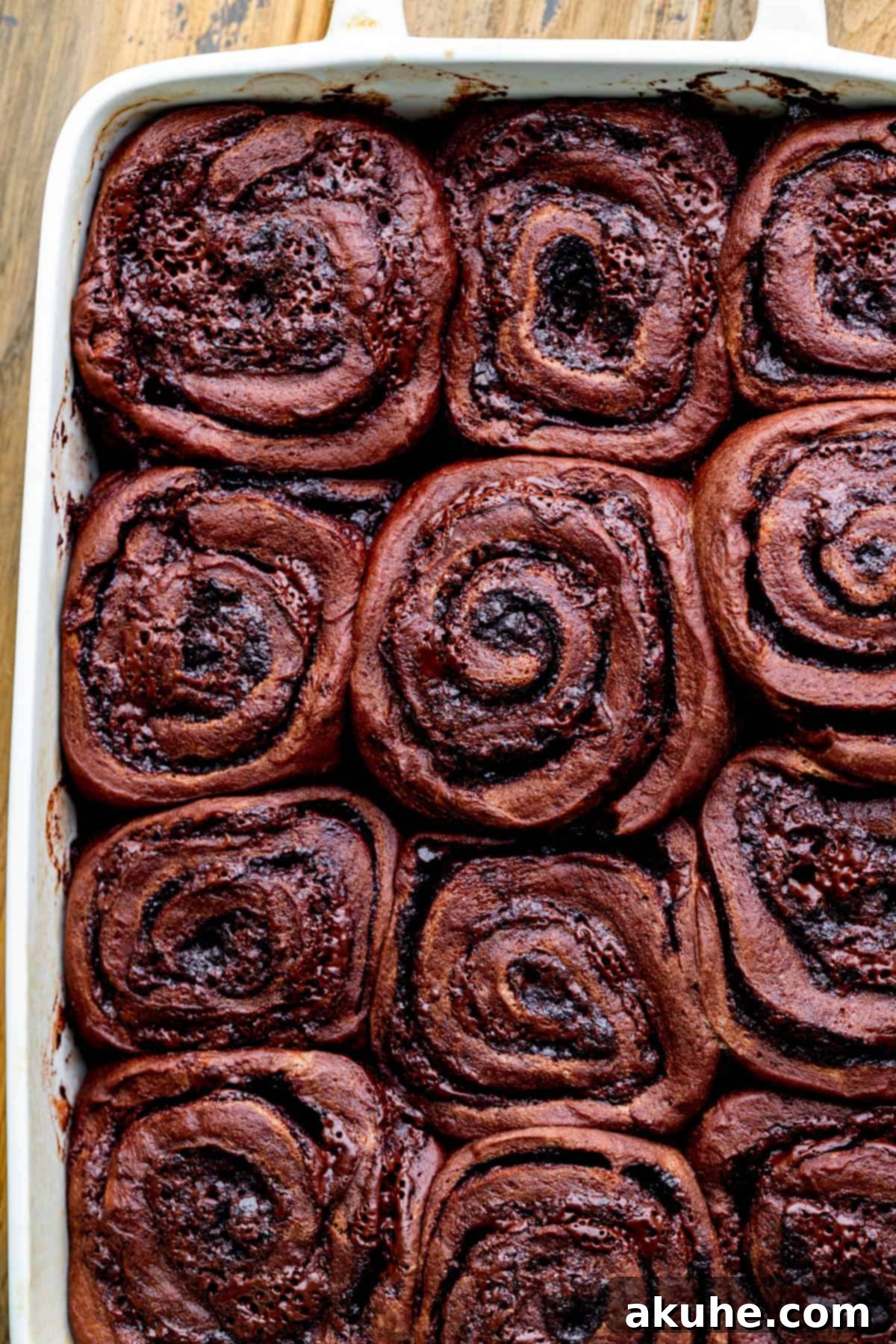 Decadent Chocolate Rolls 8 Freshly baked chocolate rolls, golden brown and bubbling in a baking pan.