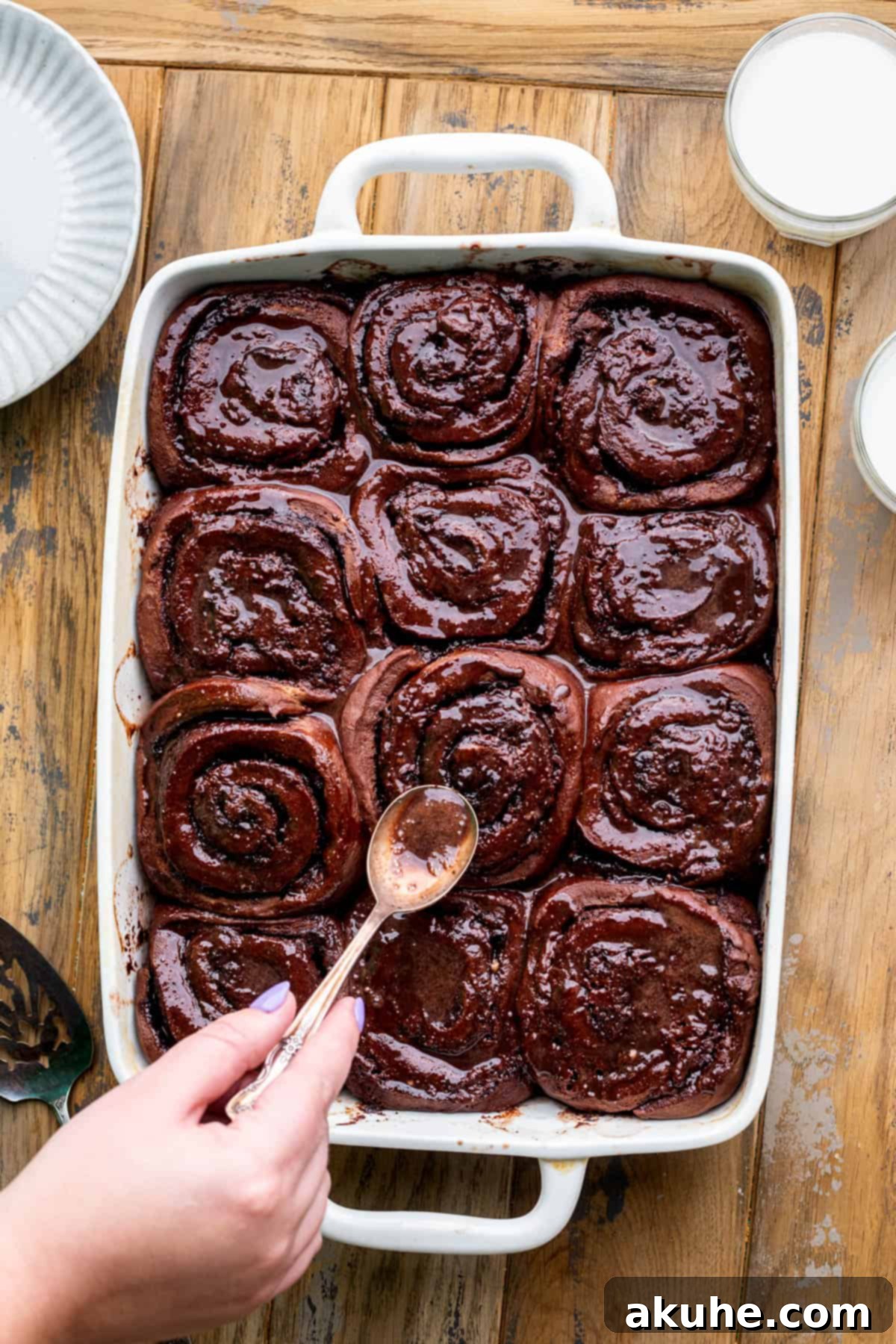 Decadent Chocolate Rolls 9 Spreading chocolate icing generously over the warm, baked chocolate rolls.