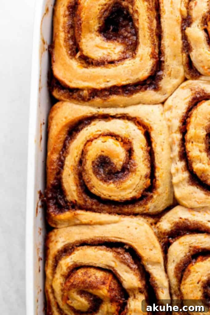Carrot Cake Cinnamon Swirls 8 Baked cinnamon rolls in a pan, golden brown and perfectly risen.
