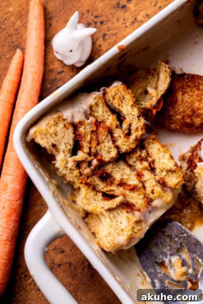 Carrot Cake Cinnamon Swirls 9 One baked carrot cake cinnamon roll cut in half in the pan, revealing the beautiful swirls of filling.