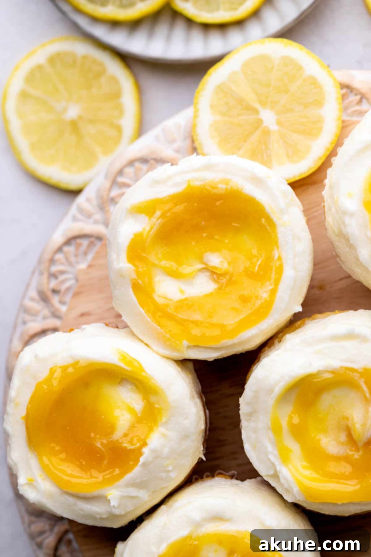Beautifully decorated lemon bar cupcakes arranged artfully on a rustic wood board, showcasing their vibrant yellow frosting and delicate lemon filling swirl.