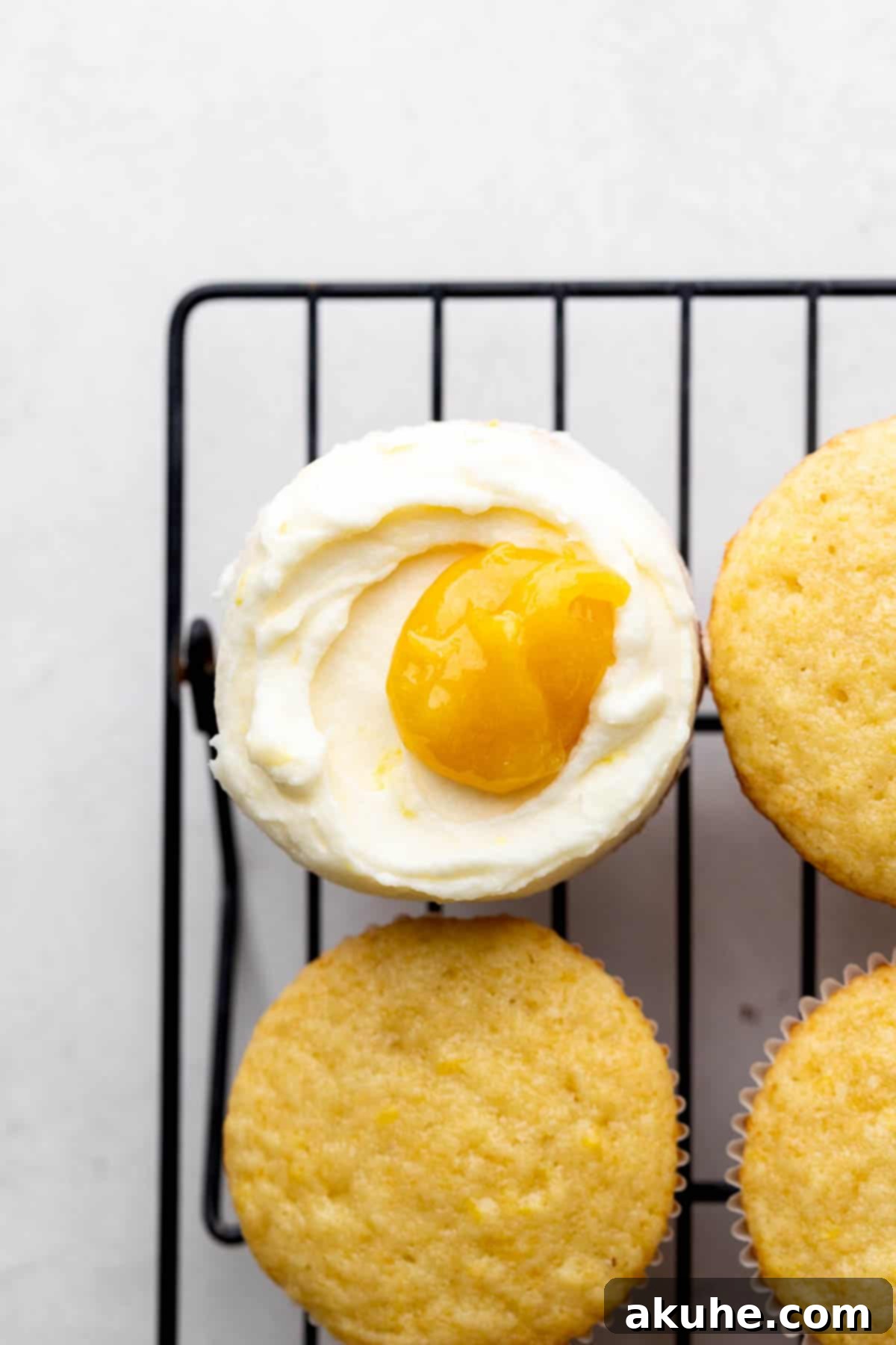 A lemon bar cupcake topped with lemon cream cheese frosting and a swirl of lemon filling.