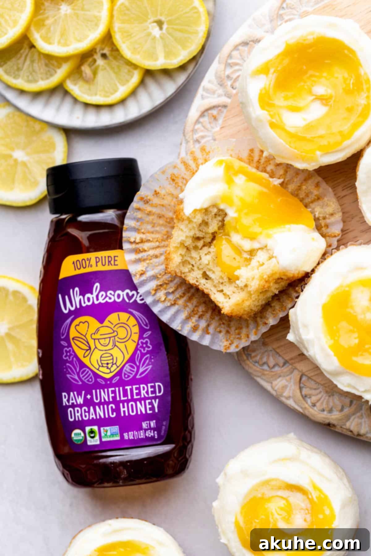 Close-up top view of two lemon bar cupcakes, one with a missing bite revealing the bright lemon filling inside.