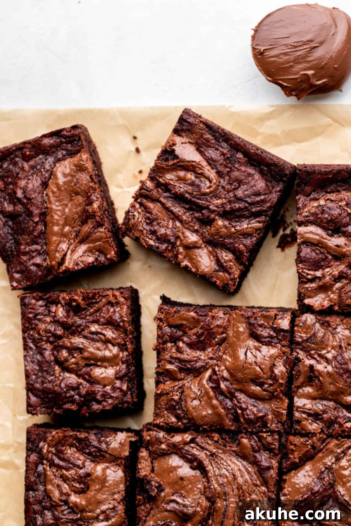 Decadent Nutella Brownies 10 Nutella brownies arranged neatly on parchment paper, ready to be served or stored.