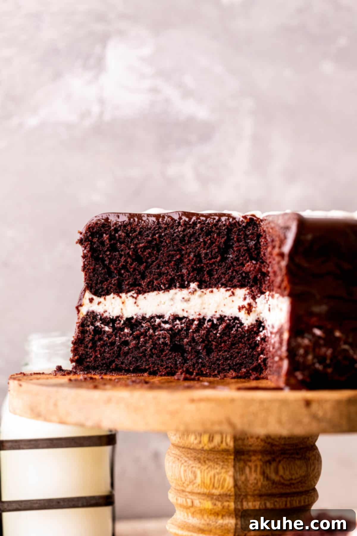 Creamy Chocolate Fudge Cake 3 Cake cut into on a cake stand.
