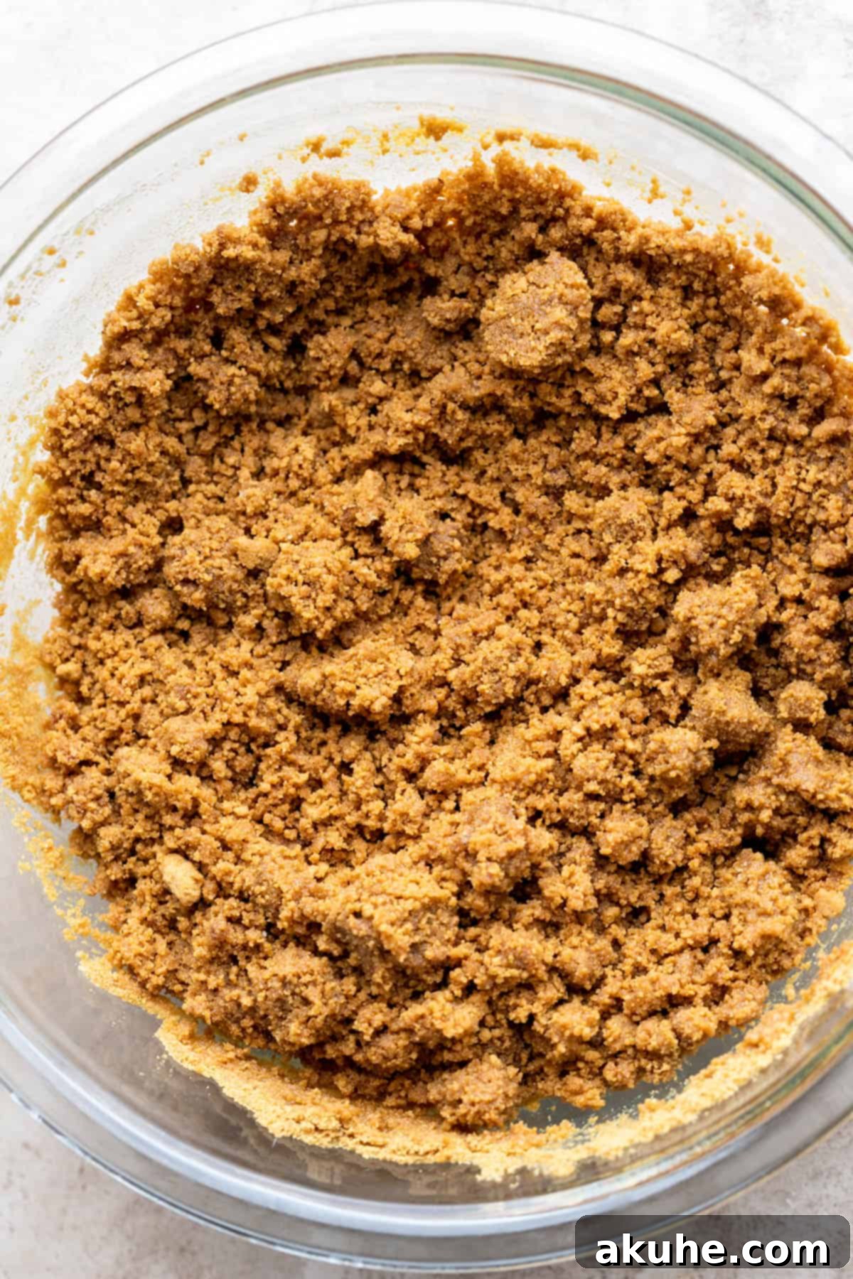 Decadent Gluten-Free Cheesecake 4 Gluten free graham cracker crumbs in a glass bowl, perfectly blended and ready for mixing.