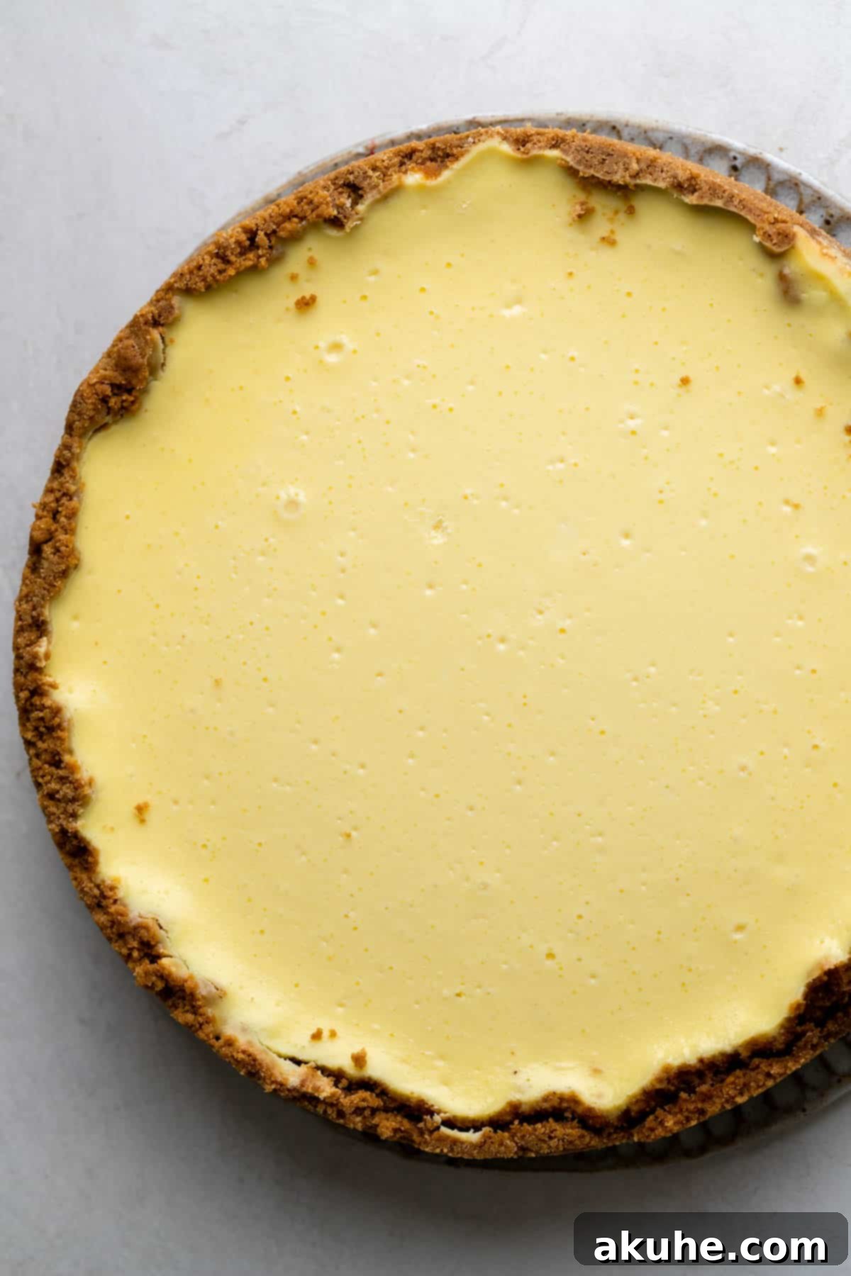 Decadent Gluten-Free Cheesecake 9 A perfectly baked, crack-free gluten-free cheesecake resting on a wooden board, fresh from the oven.