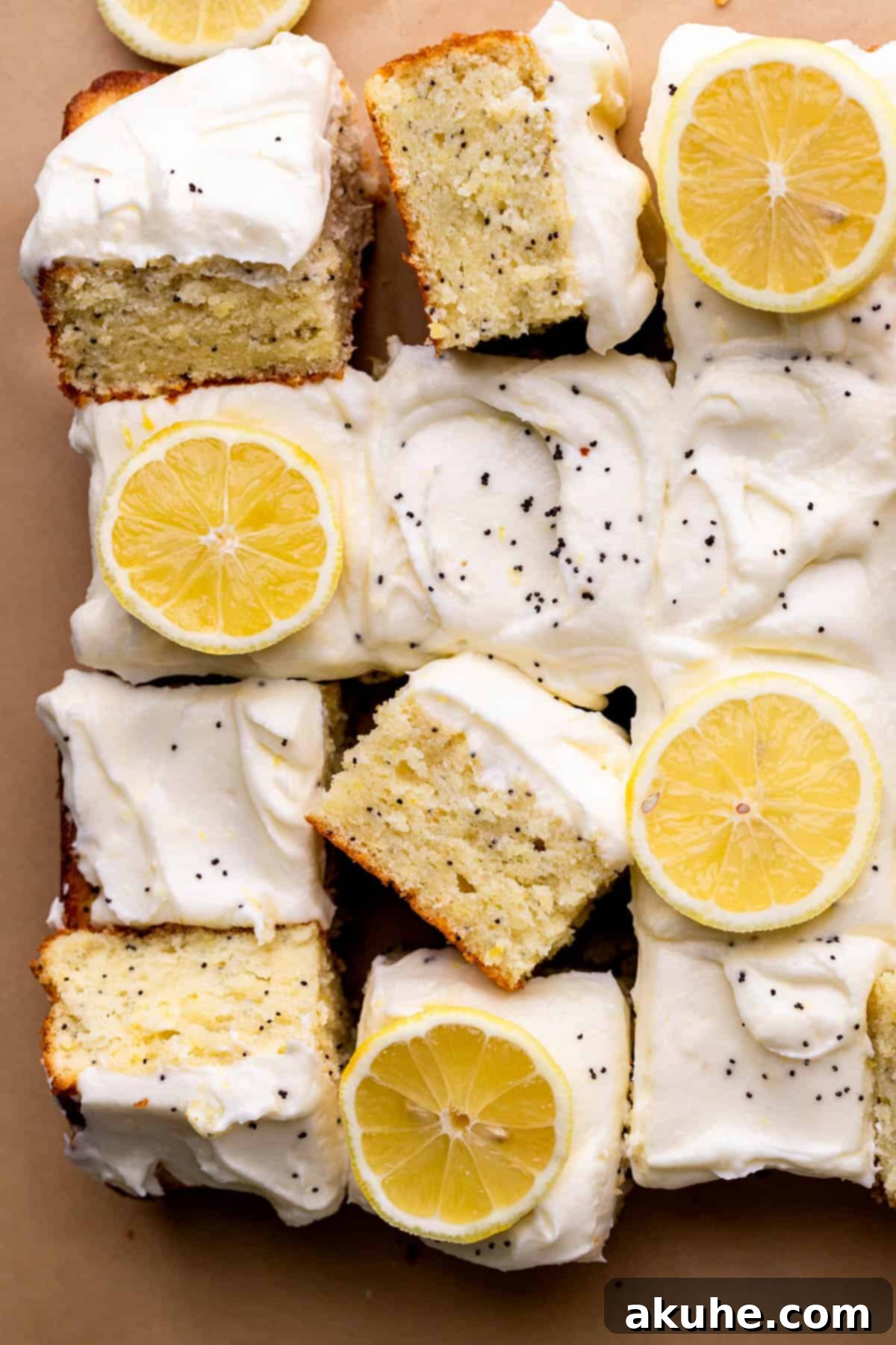 Bright Lemon Poppy Seed Cake 2 A beautifully sliced lemon poppy seed cake, showing its moist crumb and the creamy lemon frosting. Slices are arranged artfully beside the main cake.