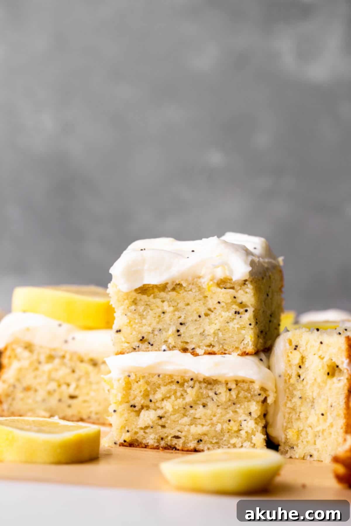 Bright Lemon Poppy Seed Cake 9 A delightful stack of two lemon poppy seed cake slices, showcasing the layers of cake and generous frosting.