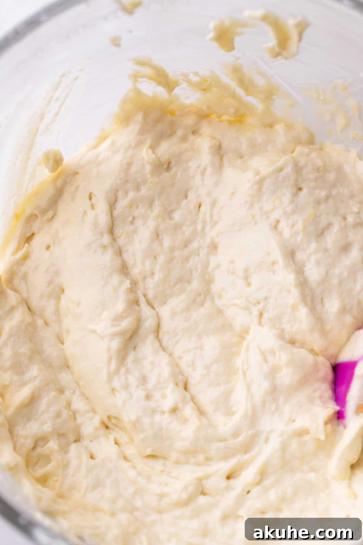 Smooth lemon cake batter in a glass bowl, ready for baking.