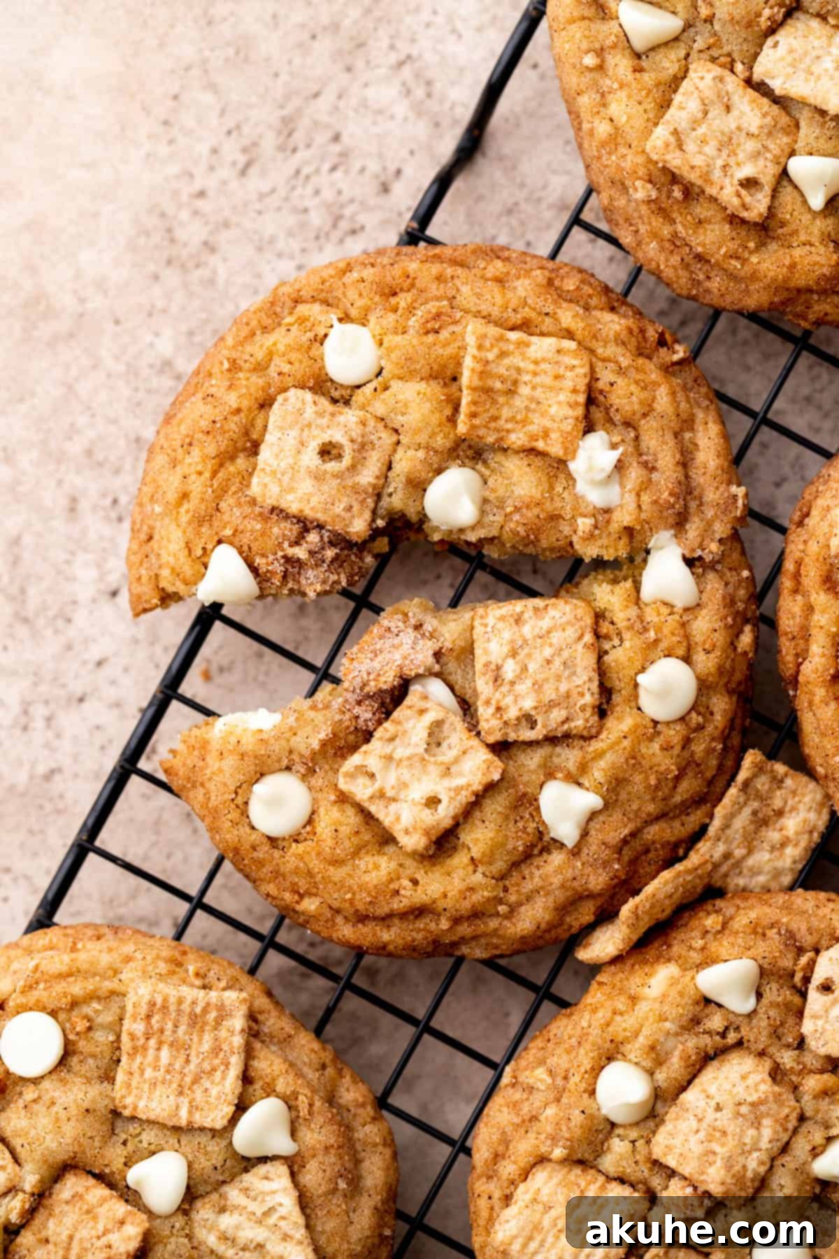 Crunchy Cinnamon Toast Cereal Cookies 2 One cinnamon toast crunch cookie split in half, showing its chewy interior with white chocolate chips and cereal crumbs.