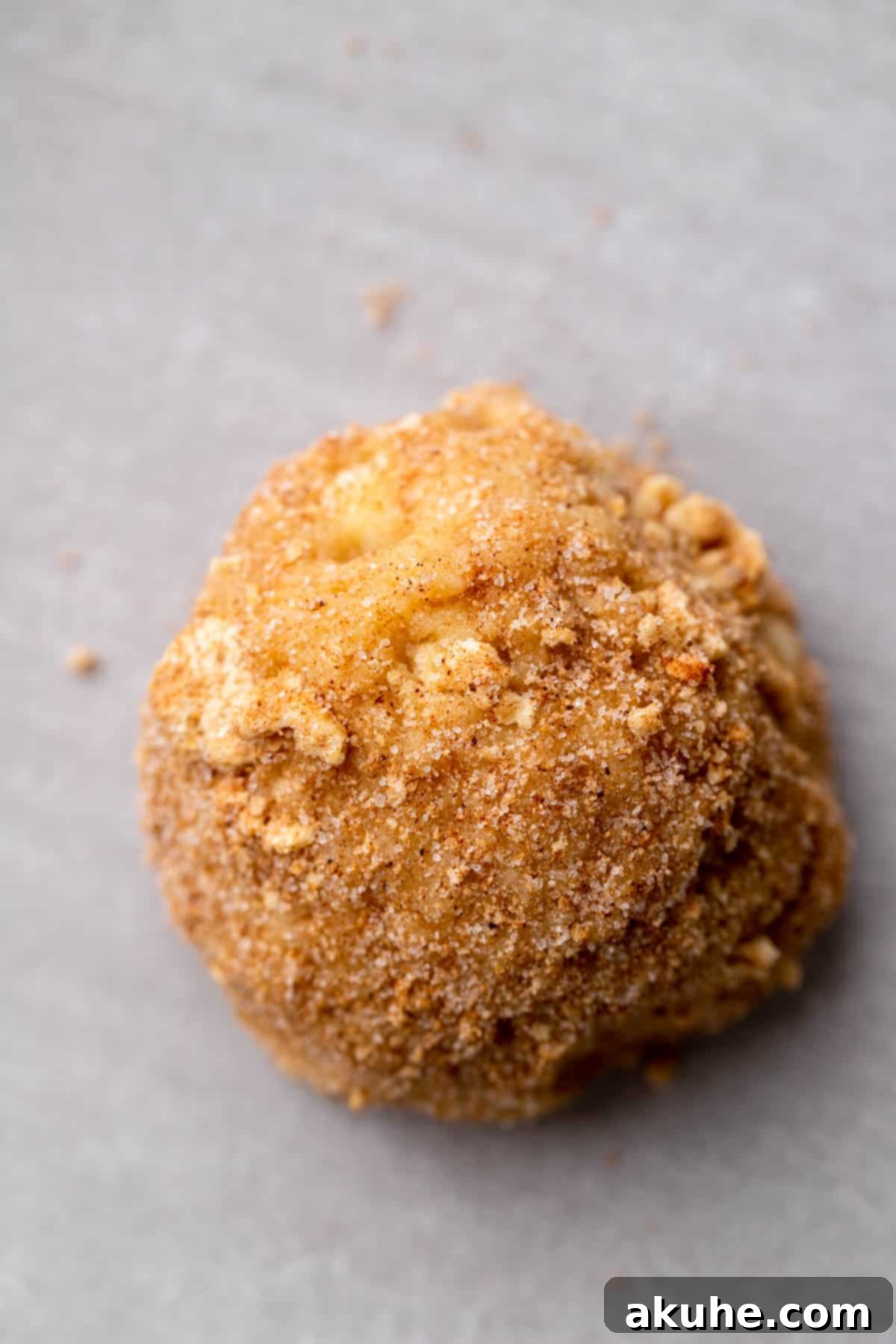 Crunchy Cinnamon Toast Cereal Cookies 8 Cinnamon Toast Crunch cookie dough balls arranged on a parchment-lined cookie sheet, ready for baking.
