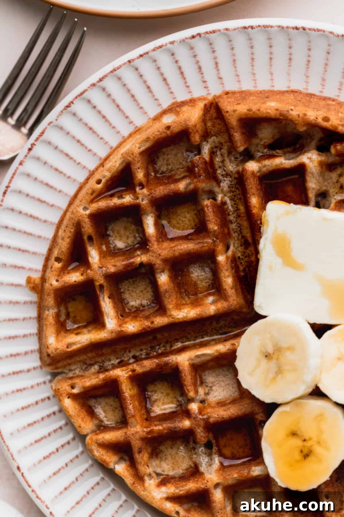 A close-up view of a perfectly cooked banana waffle, showcasing its deep pockets and golden-brown, crispy edges.