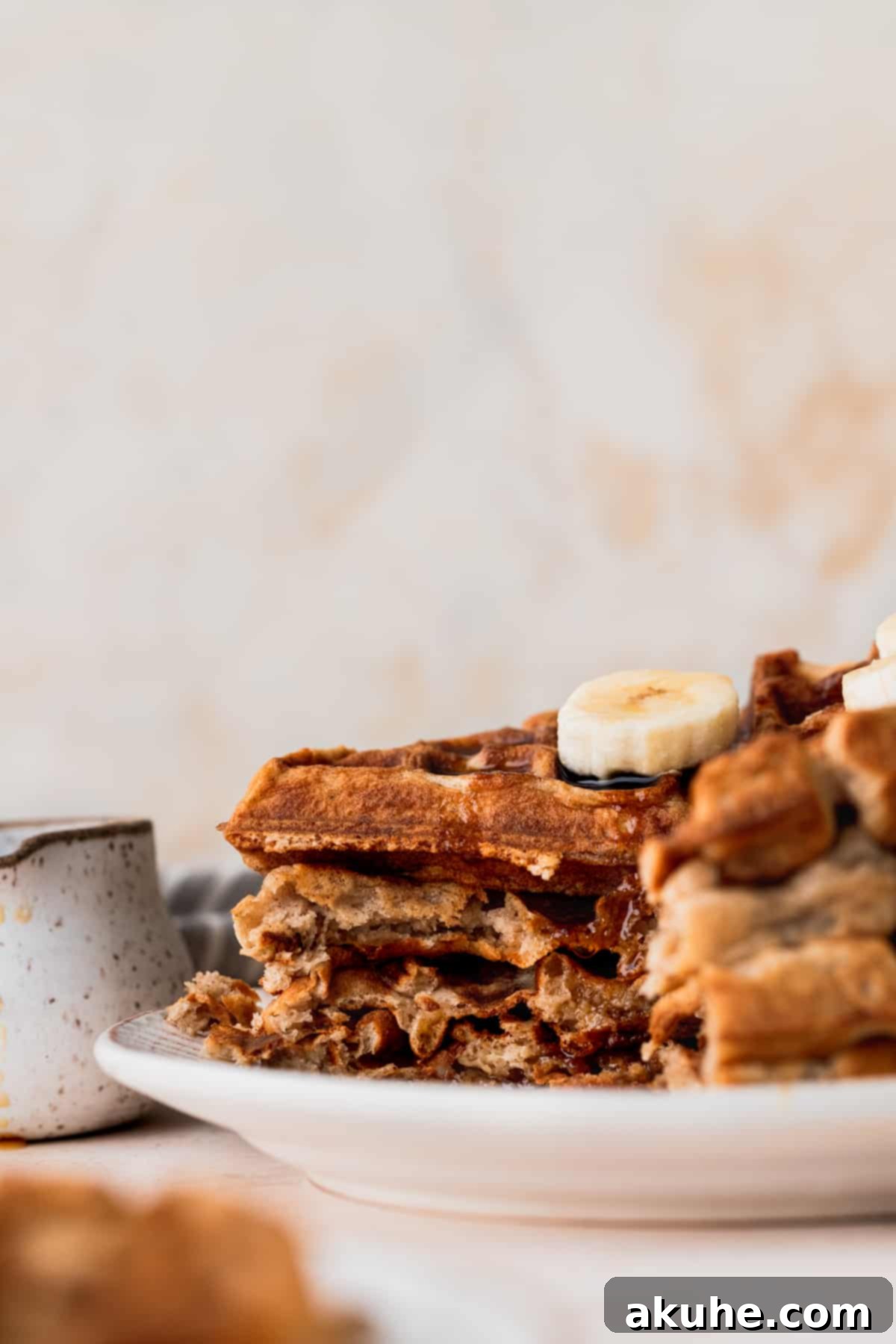 A stack of perfectly cut banana waffles, revealing their airy interior and fluffy texture.