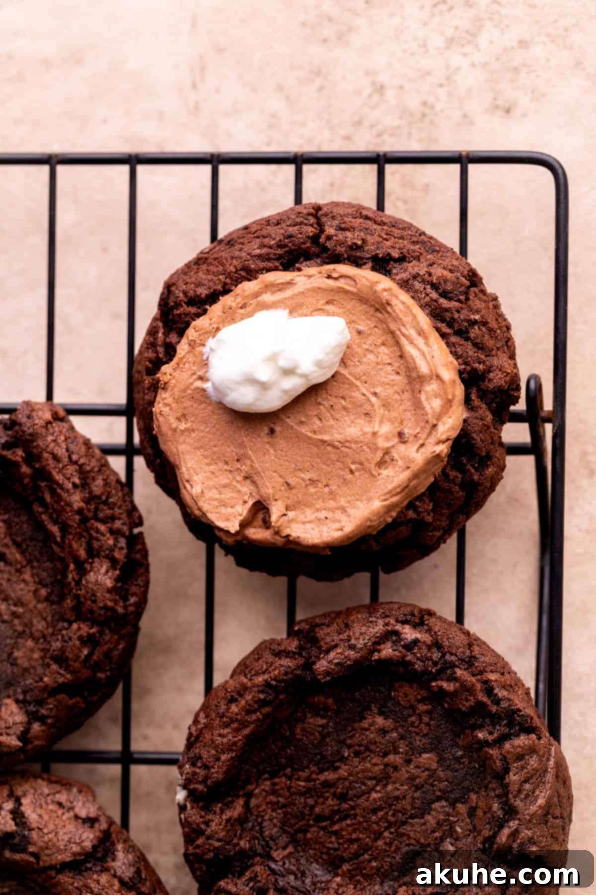 Whipped cream dollop swirled on top of the chocolate filling in a cookie.