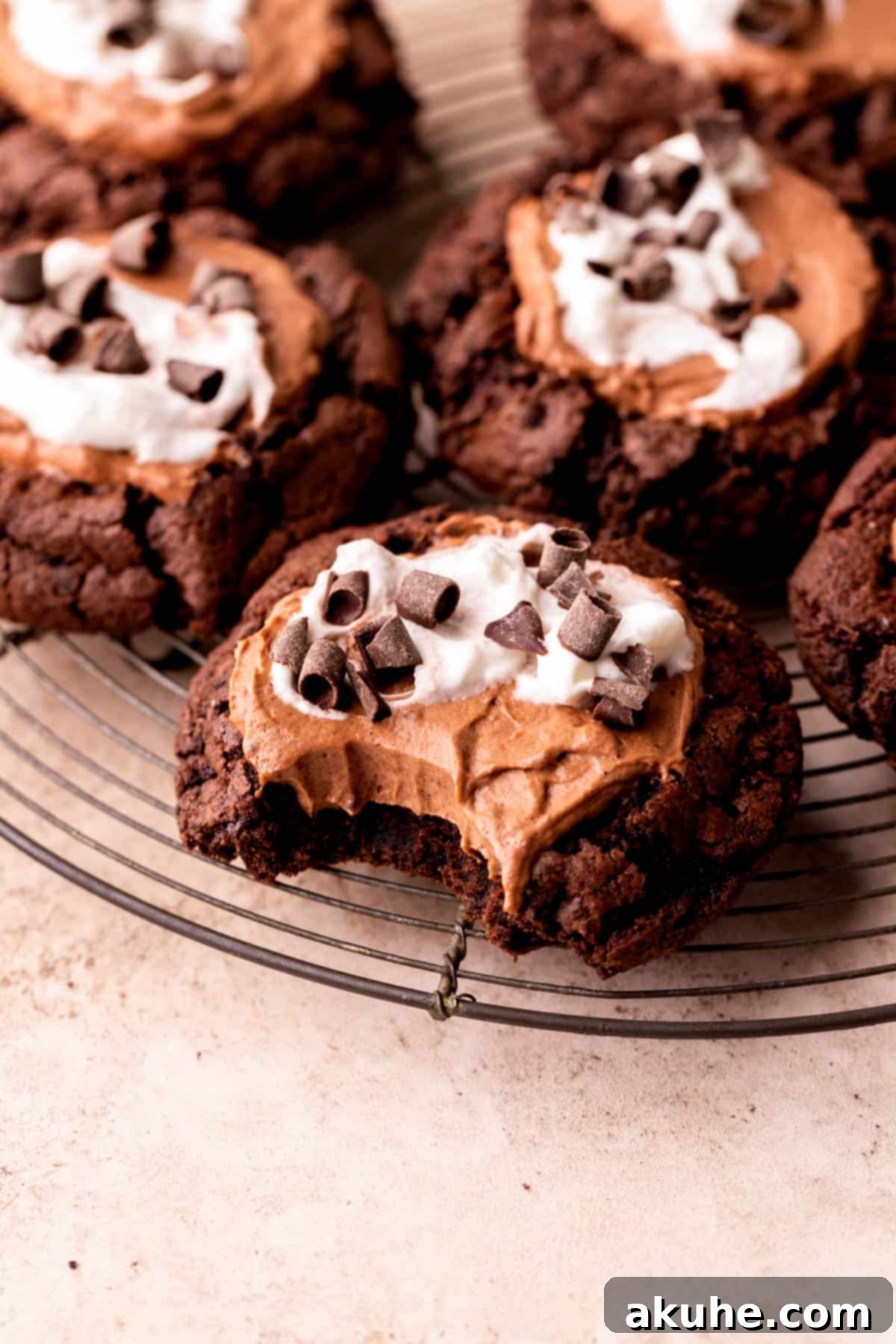 A French Silk Pie Cookie with a bite missing, showing the layers of chocolate cookie, mousse, and whipped cream.
