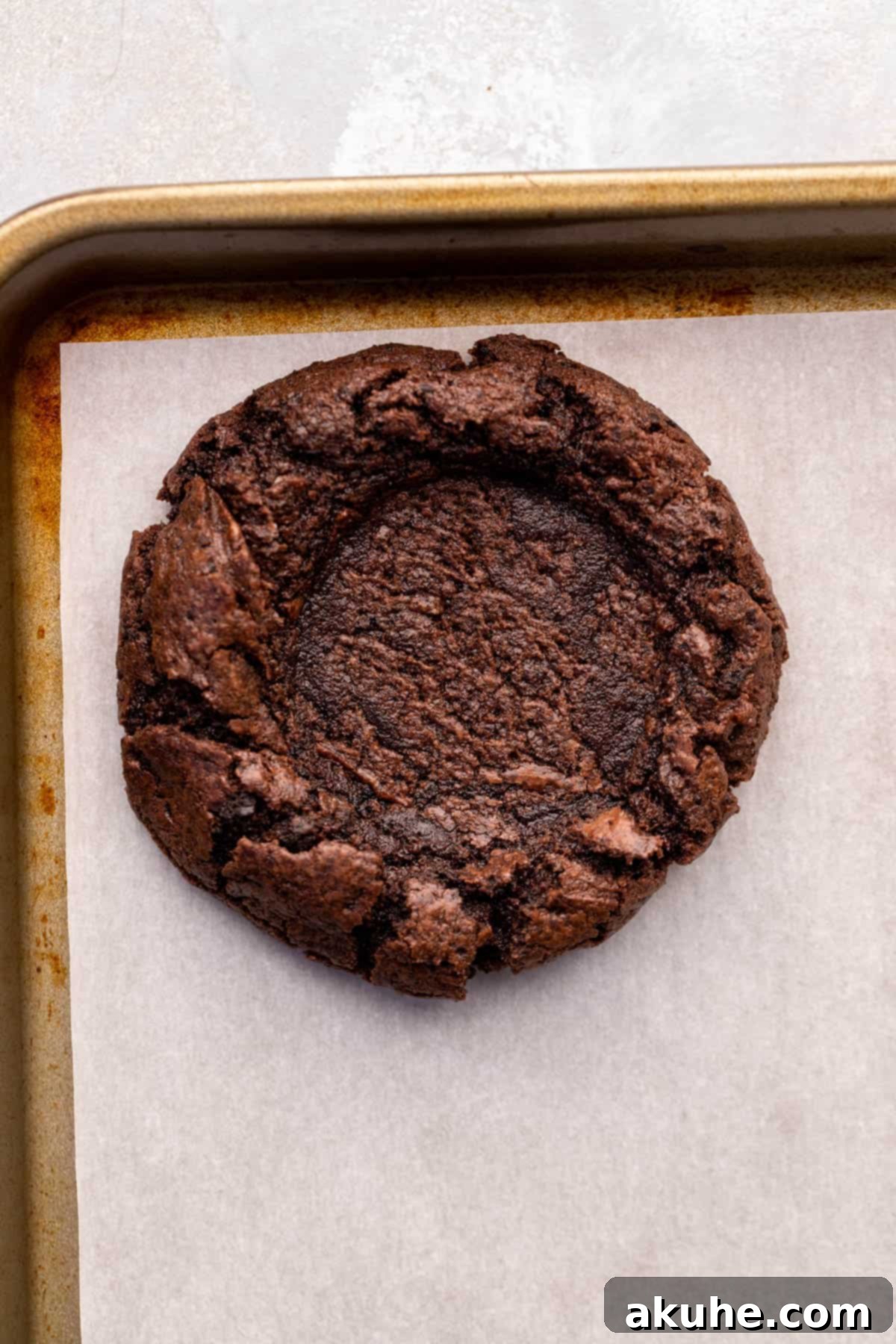 Baked chocolate cookie with a perfect indentation in the center.