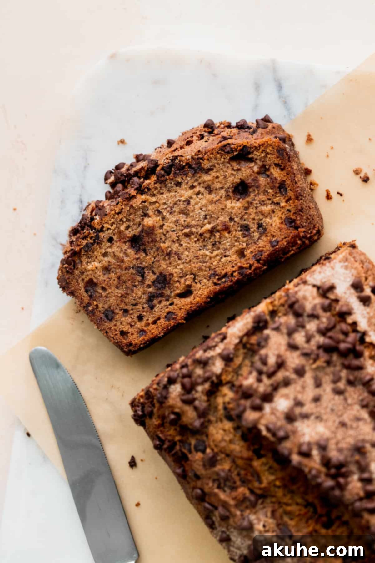 Cinnamon Swirl Chocolate Chip Banana Bread 3 Taking a slice of freshly baked cinnamon chocolate chip banana bread from the loaf pan.