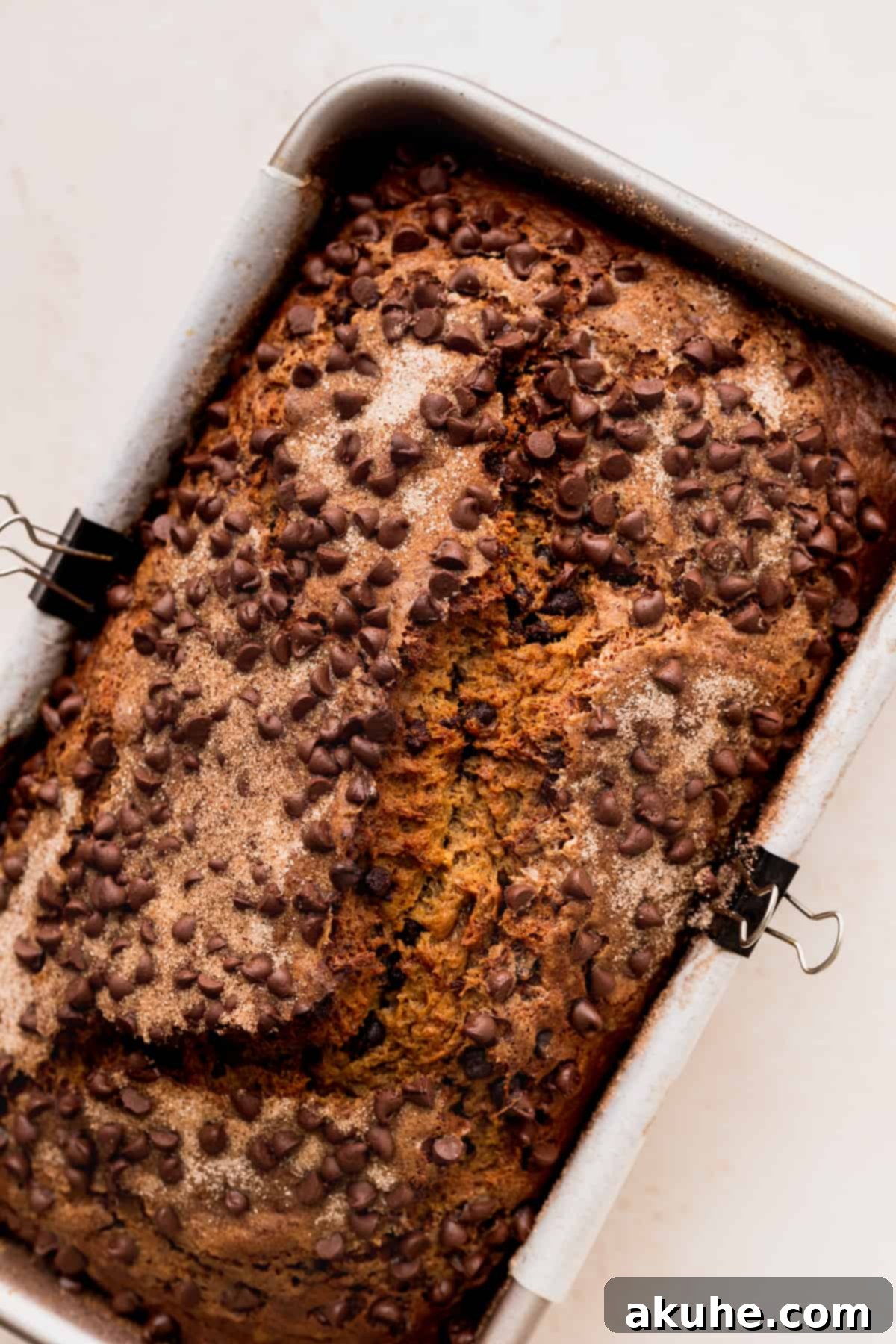 Cinnamon Swirl Chocolate Chip Banana Bread 8 A perfectly golden-brown baked banana bread in its loaf pan.