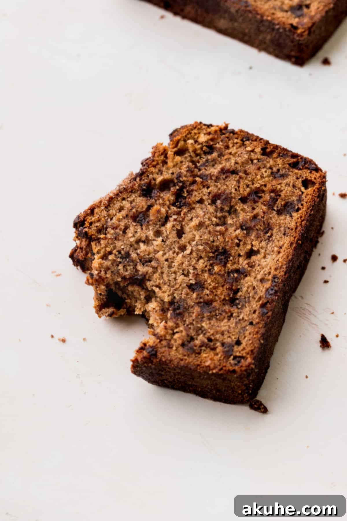Cinnamon Swirl Chocolate Chip Banana Bread 10 A bite taken out of a slice of Cinnamon Chocolate Chip Banana Bread, showcasing its moist texture.