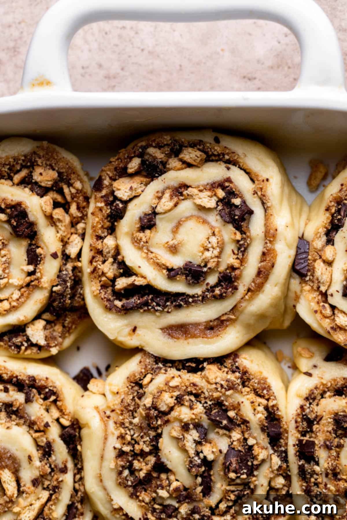 Gooey S'mores Cinnamon Buns 7 Raw cinnamon rolls arranged in a baking pan, puffy and ready for the oven after their second rise.