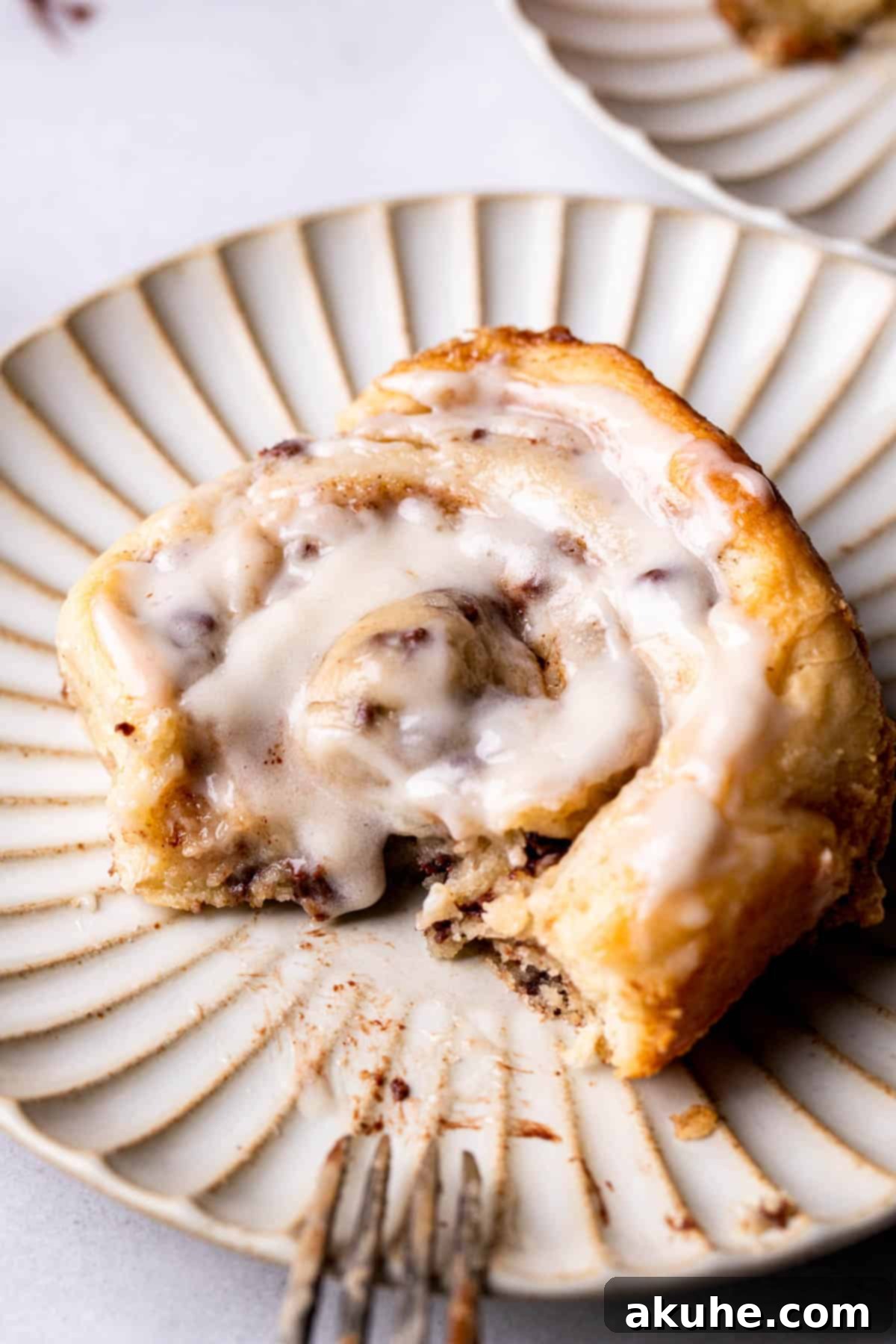 Cookie Dough Swirled Cinnamon Buns 12 A cookie dough cinnamon roll with a bite taken out, showing the layered filling.