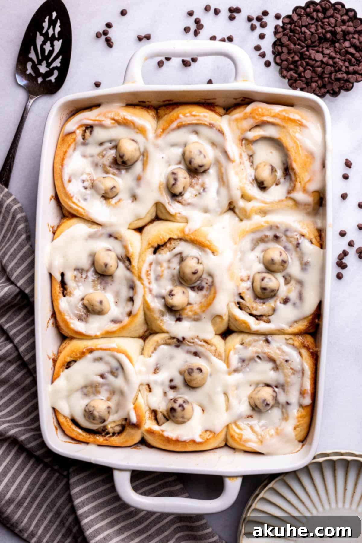 Cookie Dough Swirled Cinnamon Buns 3 Warm Cookie Dough Cinnamon Rolls arranged in a baking pan, ready to be iced.