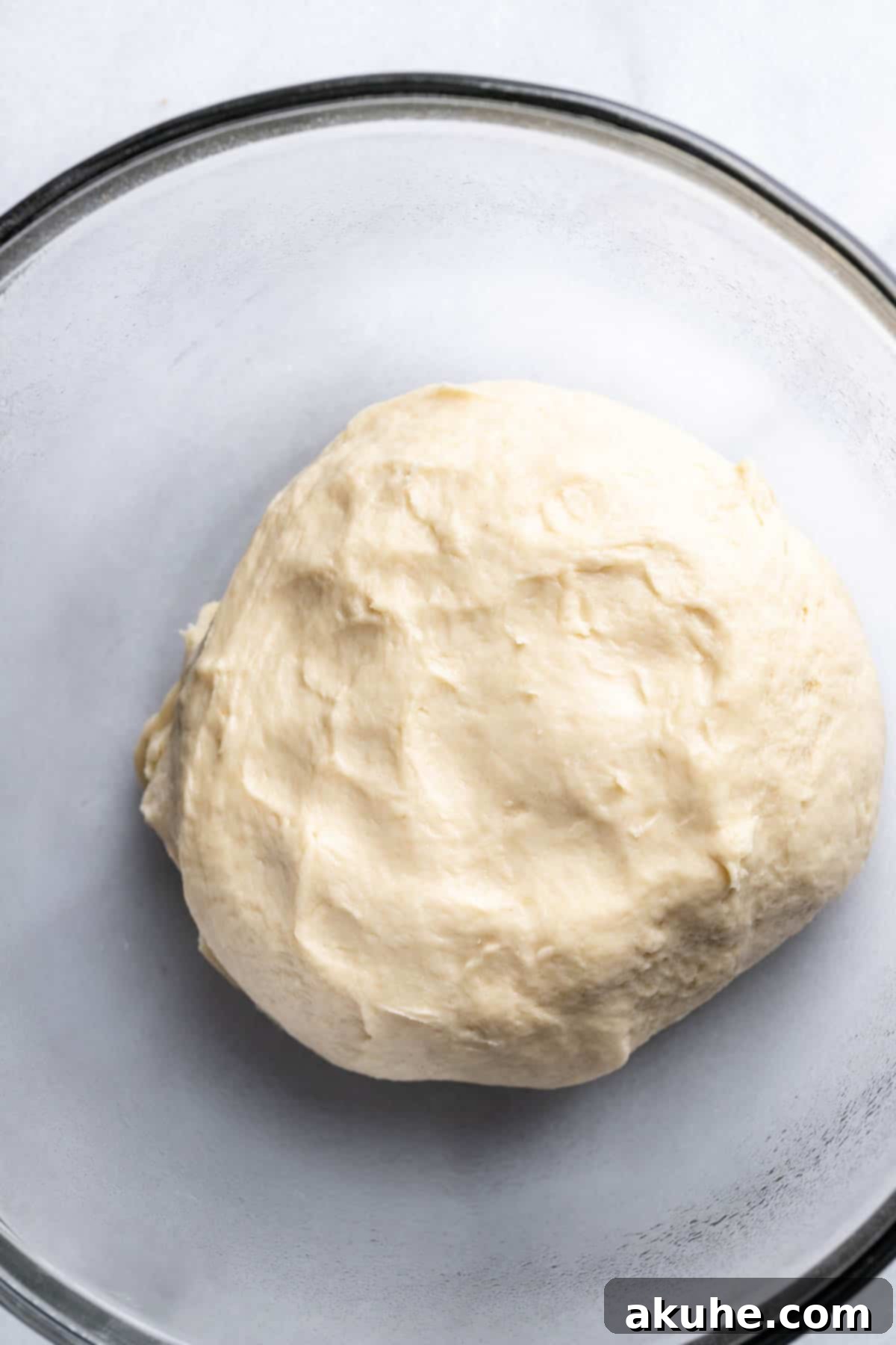 Cookie Dough Swirled Cinnamon Buns 4 Unrisen dough resting in a clear glass bowl before proofing.