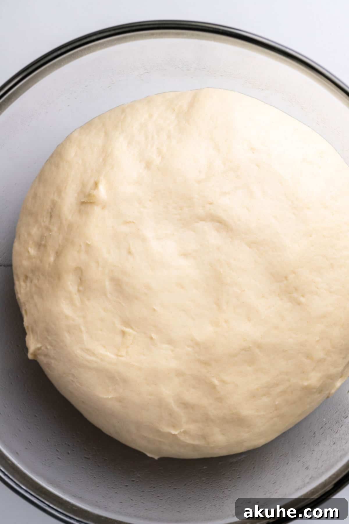Cookie Dough Swirled Cinnamon Buns 5 Fully risen dough, doubled in size, in a glass bowl.