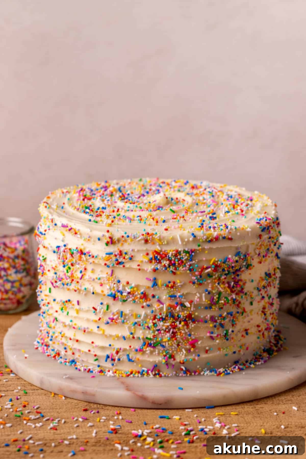 Festive Sprinkled Cake 9 A beautifully decorated Funfetti cake on a white cake platter, ready for serving.