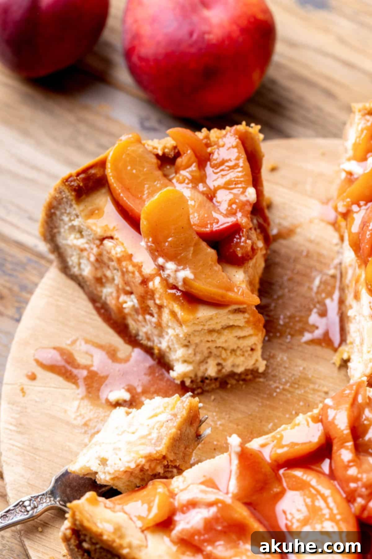 Luscious Peach Cheesecake 2 Fork inserted into a rich, creamy slice of peach cheesecake, showcasing the layered texture.