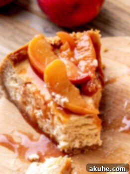 Luscious Peach Cheesecake 12 Fork inserted into a peach cheesecake slice.