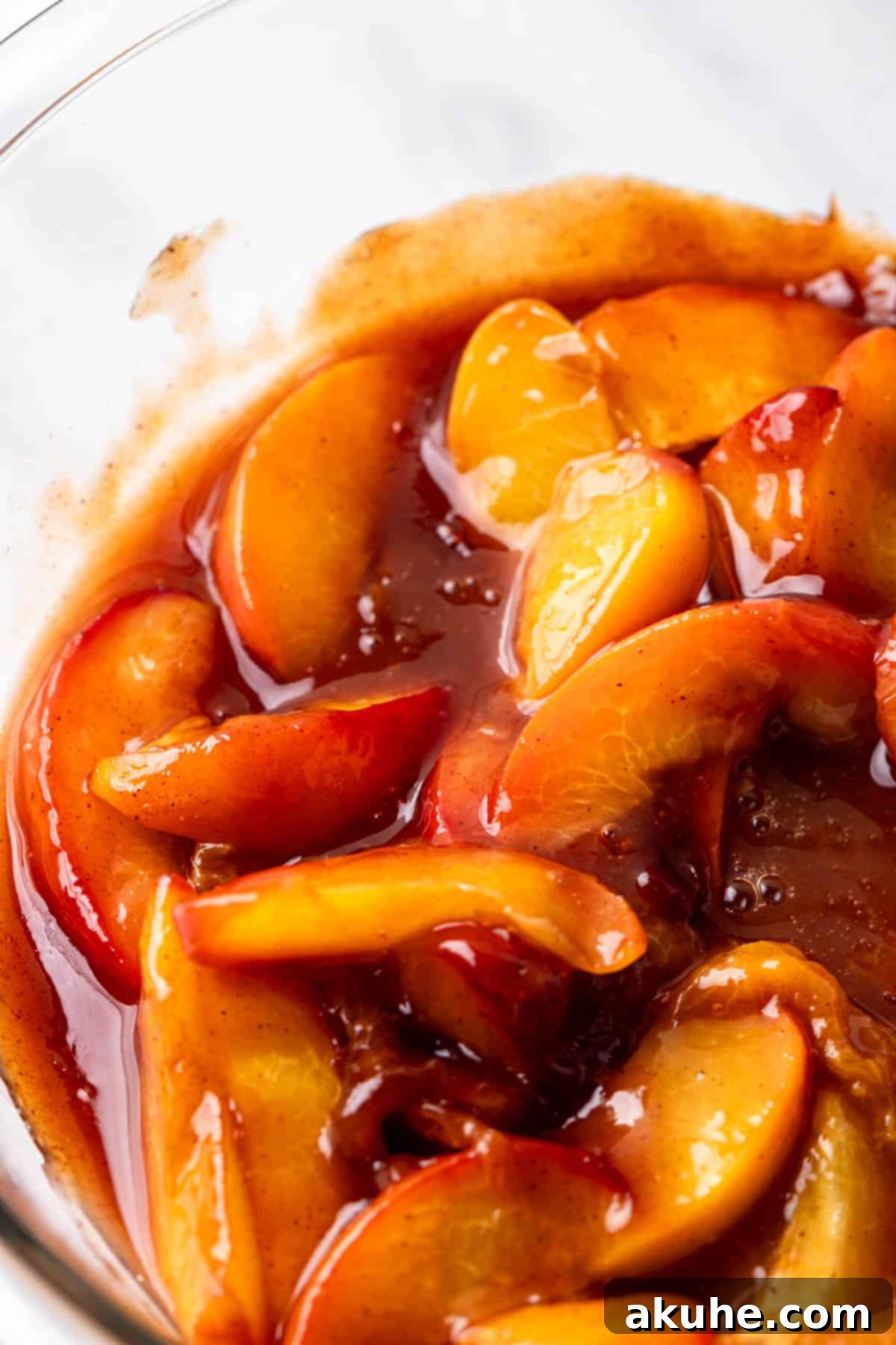 Luscious Peach Cheesecake 4 A glass bowl filled with rich, cooked peach cobbler filling, ready to be incorporated into the cheesecake.