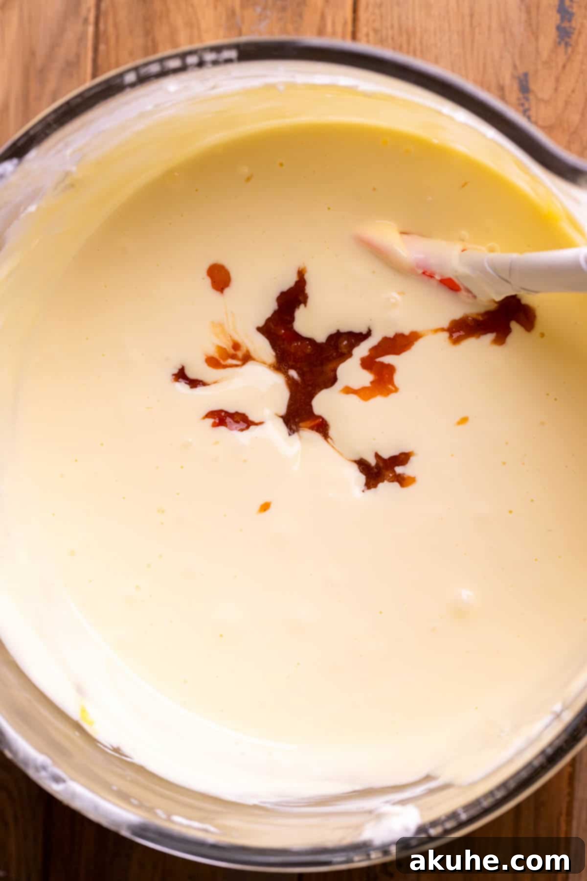 Luscious Peach Cheesecake 6 Smooth peach filling carefully placed on top of creamy cheesecake batter in a bowl.