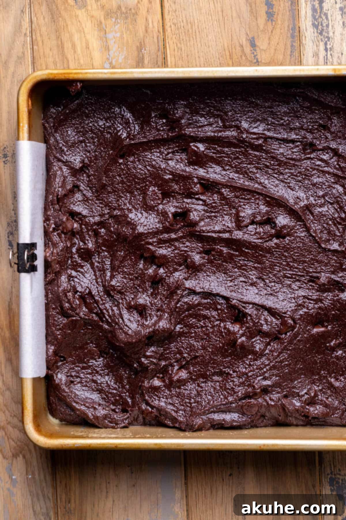 Decadent Cookie Dough Brownies 6 Unbaked brownie batter spread evenly in a parchment-lined baking pan.