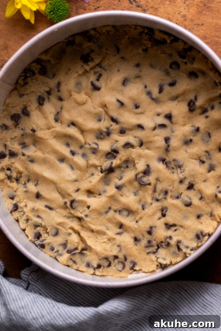 Chocolate chip cookie dough pressed into the bottom of a springform pan.