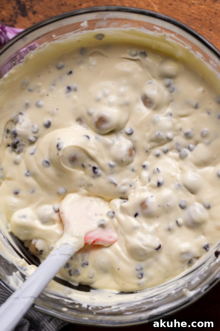 Silky smooth cheesecake batter with chocolate chips in a large mixing bowl.