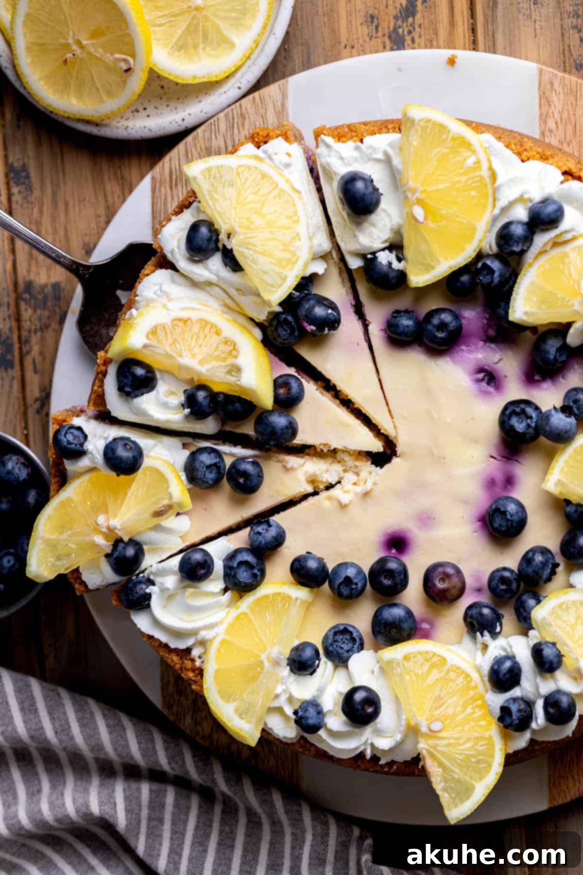 Zesty Lemon Blueberry Cheesecake 2 Decorated lemon blueberry cheesecake on a board, showcasing its vibrant colors and creamy texture.