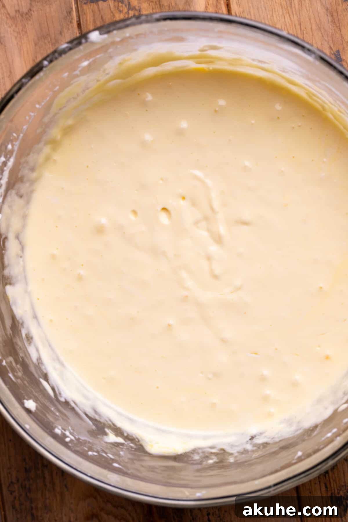 Zesty Lemon Blueberry Cheesecake 5 Smooth and creamy cheesecake batter in a clear glass bowl, ready for additions.