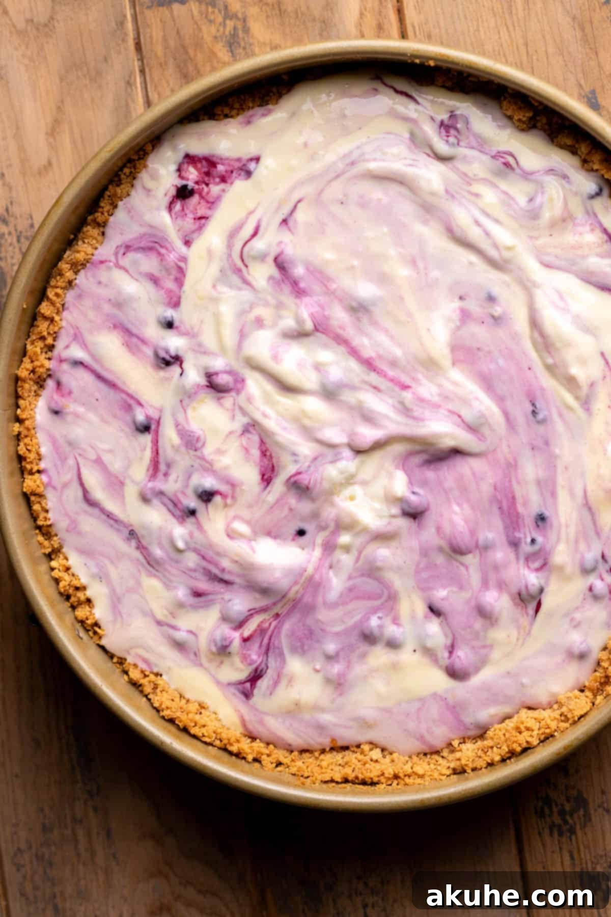 Zesty Lemon Blueberry Cheesecake 7 Lemon blueberry cheesecake batter spread evenly over the crust in a springform pan, ready for the oven.