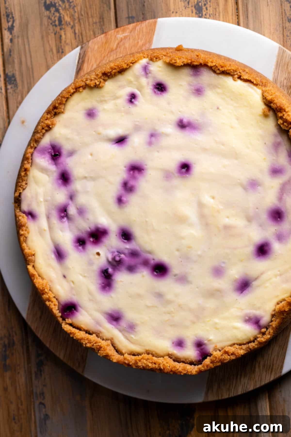 Zesty Lemon Blueberry Cheesecake 8 Freshly baked lemon blueberry cheesecake cooling on a wire rack, with its golden-brown crust and vibrant filling.