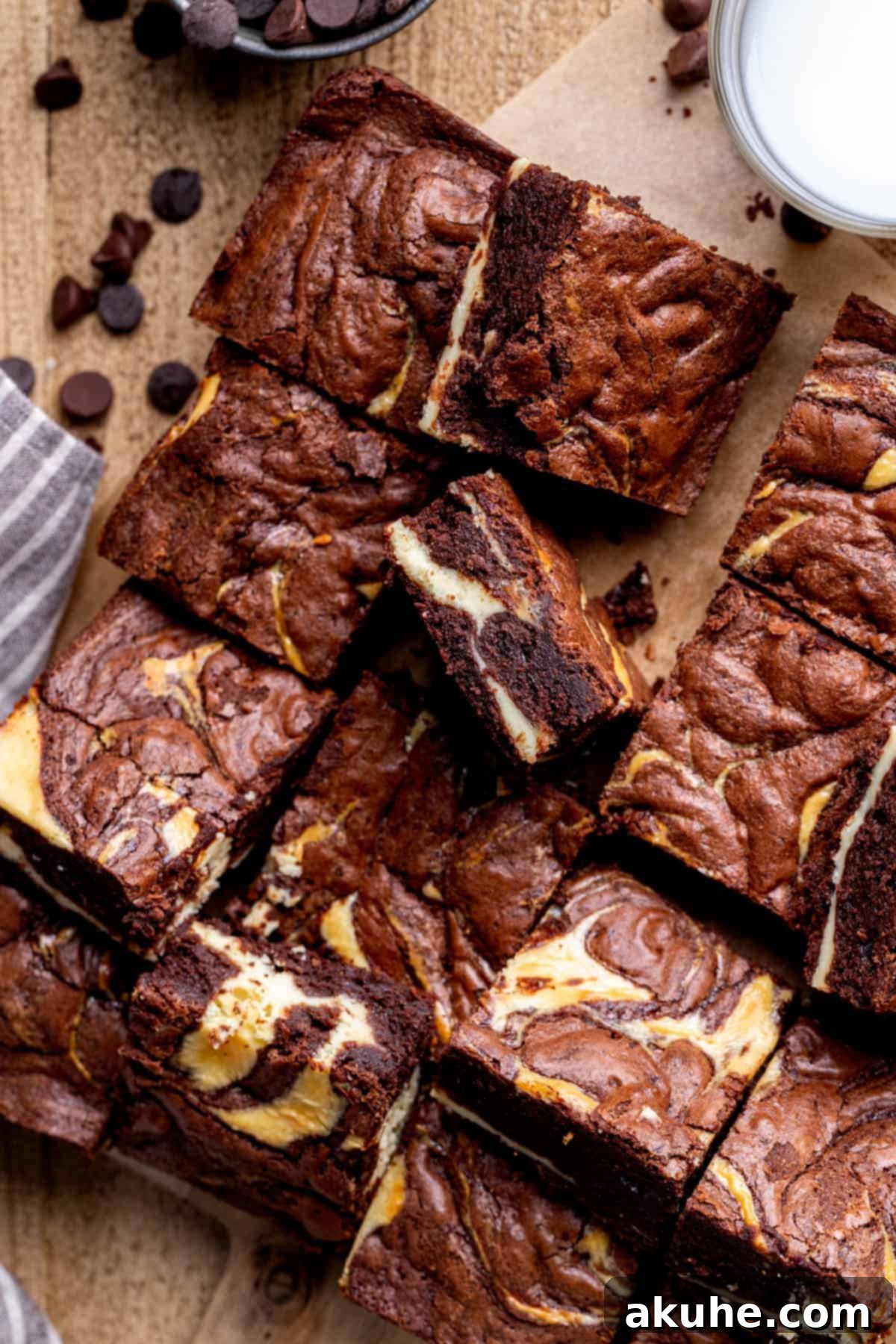 Decadent Cheesecake Brownies 11 Beautifully cut cheesecake brownies arranged on a rustic wooden board.