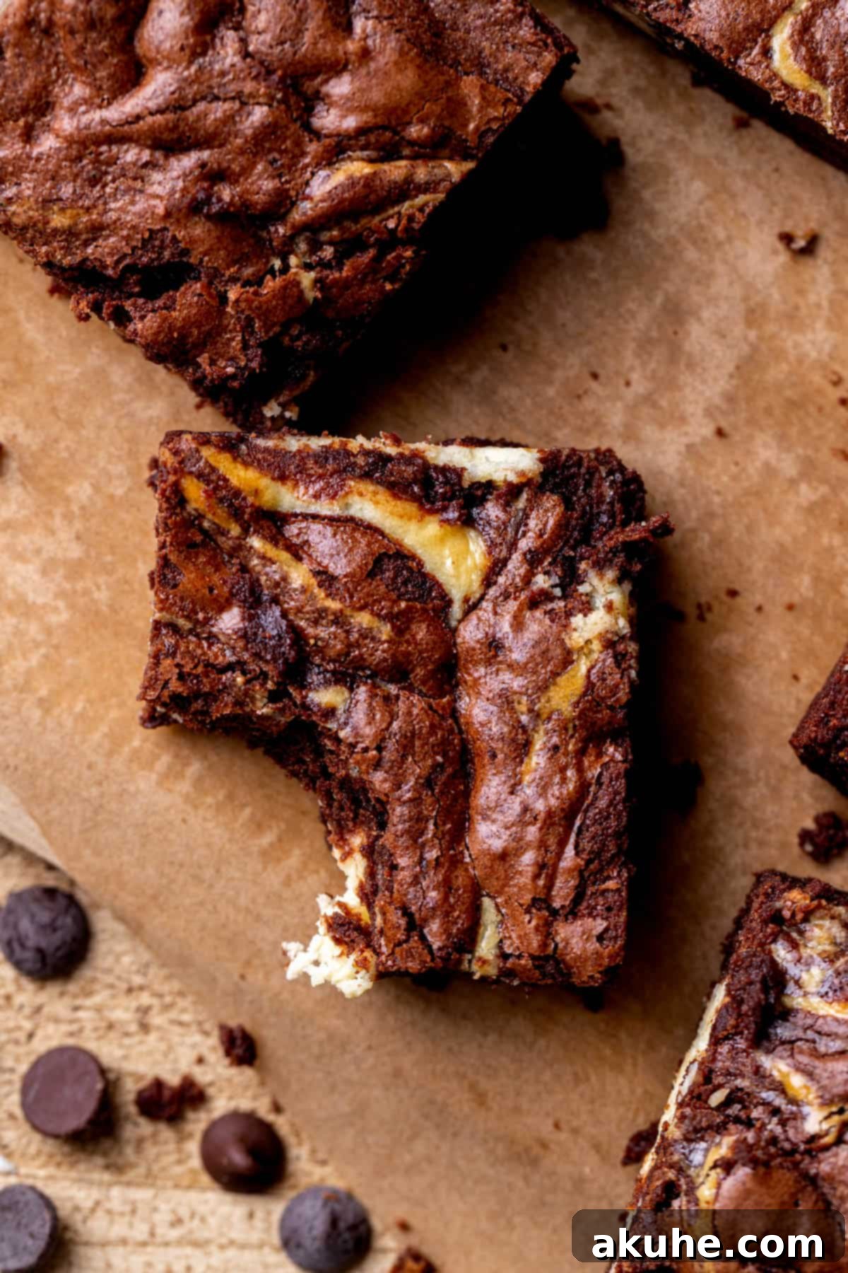 Decadent Cheesecake Brownies 3 A cheesecake brownie with a bite missing, showing the fudgy texture and cheesecake layer.