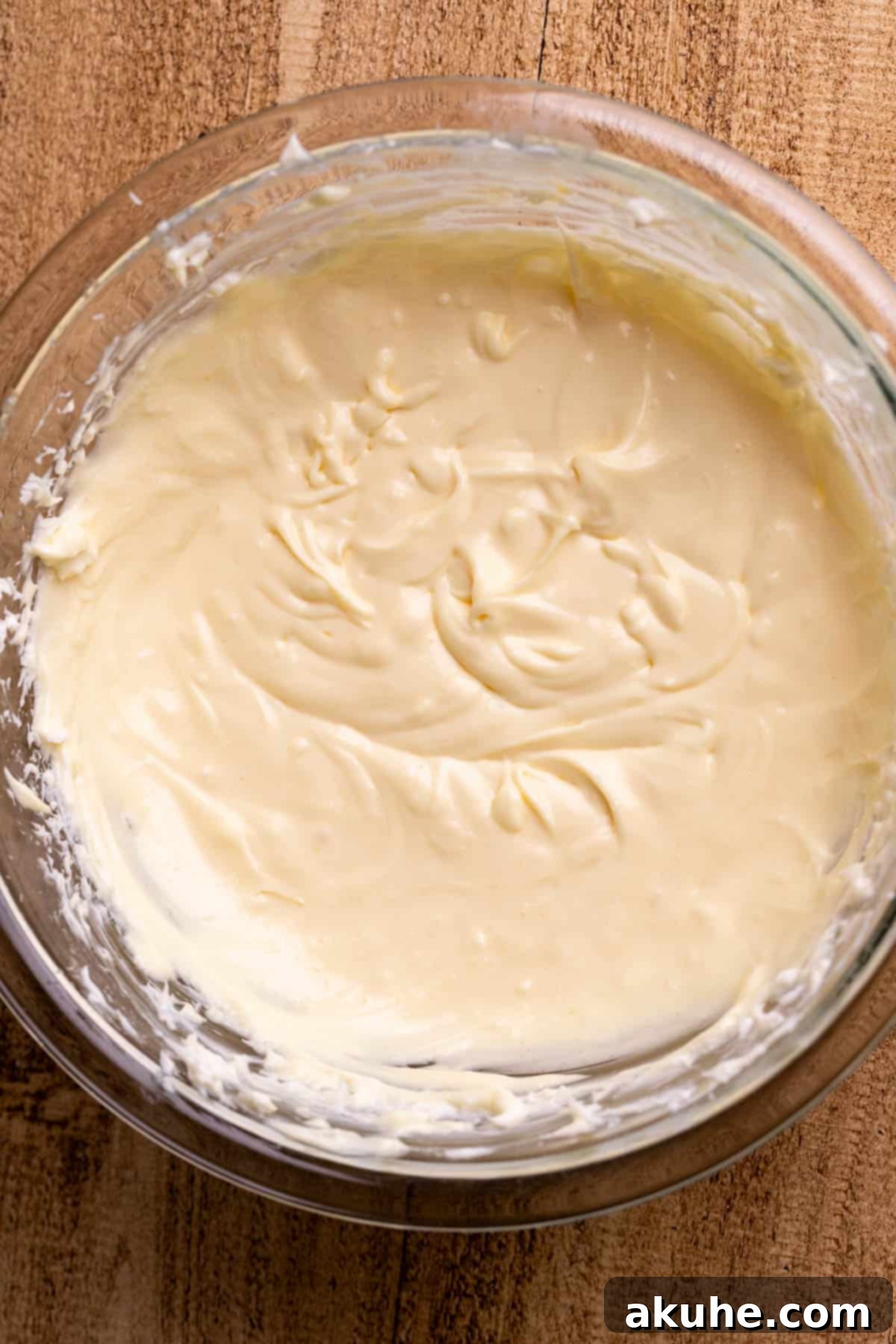 Decadent Cheesecake Brownies 4 Smooth cheesecake batter in a clear glass bowl, ready for swirling.