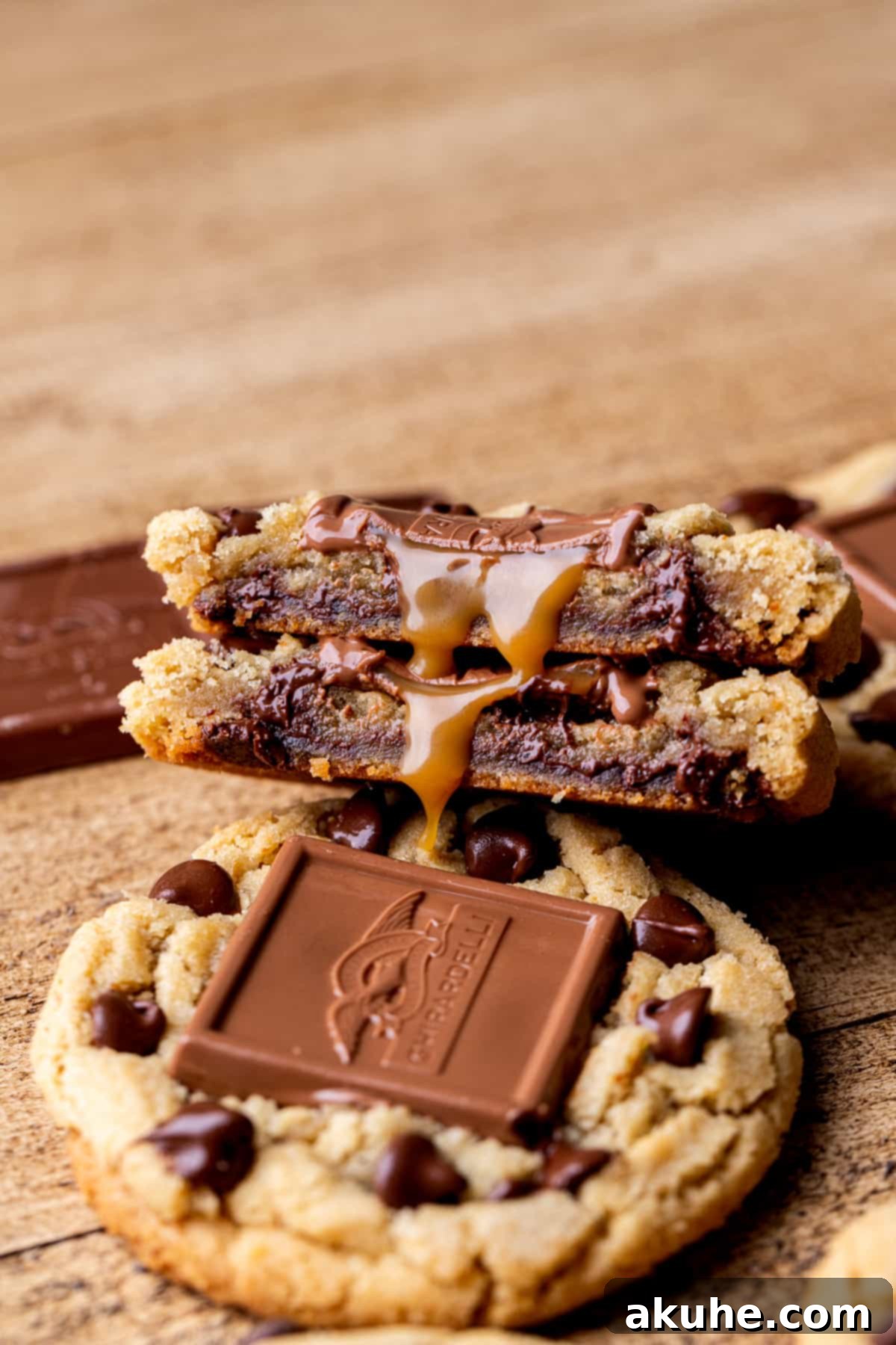 A freshly baked brown butter chocolate caramel cookie sliced in half, revealing the soft, chewy interior and the melted caramel flowing out.