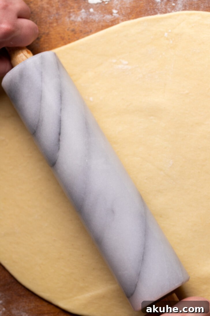 Rolling out the cinnamon roll dough into a rectangular shape.
