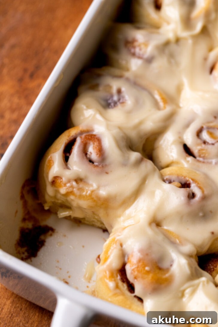 Side view of freshly baked and iced mini cinnamon rolls.