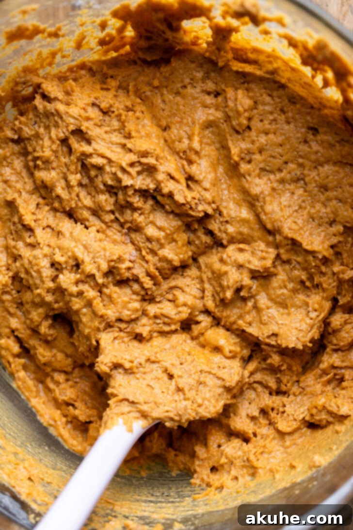 Thick pumpkin muffin batter in a mixing bowl, demonstrating the correct consistency before adding to muffin liners.